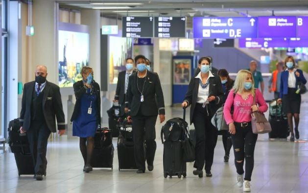 مسافرون يضعون كمامات للوقاية من فيروس كورونا في مطار فرانكفورت يوم 20 مايو 2020. تصوير: كاي فافنباخ - رويترز.